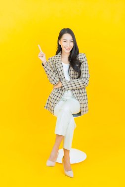 Portre güzel Asyalı kadın gülümsüyor. Renkli arka planda hareket var.