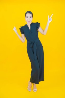 Portre güzel Asyalı kadın gülümsüyor. Renkli arka planda hareket var.