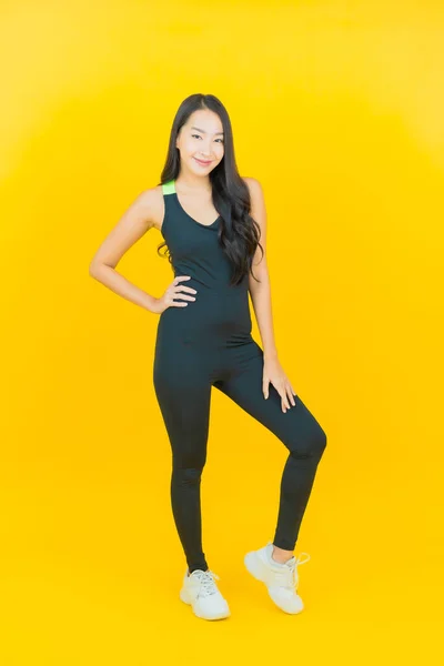 ポートレート美しい若いアジアの女性は黄色の色の背景で運動の準備ができてジムの服を着て — ストック写真
