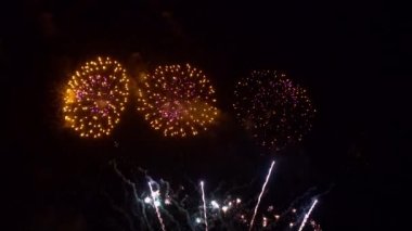 Gece gökyüzünde patlayan havai fişeklerin yakın çekim görüntüleri.
