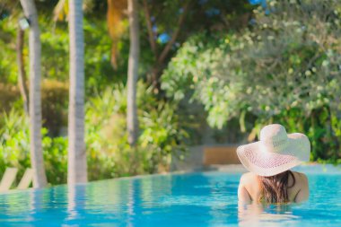 Güzel bir Asyalı kadın portresi. Mutlu bir gülümseme. Keyifli bir tatil için otel havuzunda rahatça yüzme havuzu.
