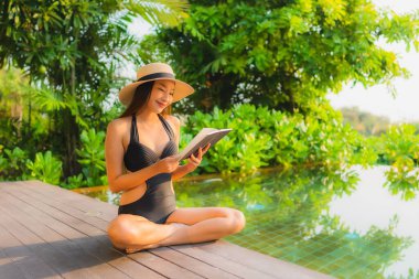 Güzel bir Asyalı kadın portresi tatil gezisi için otel havuzunda dinleniyor.