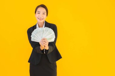 Sarıya boyanmış arka planda bir sürü nakit parası olan güzel bir Asyalı kadın portresi.