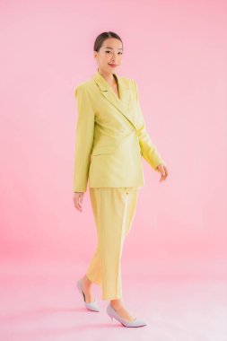 Portre güzel Asyalı genç iş kadını pembe arka planda gülümsüyor