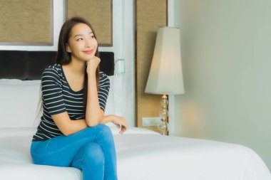 Asyalı güzel bir kadının portresi. Gülümse. Yatak odasında rahatla.