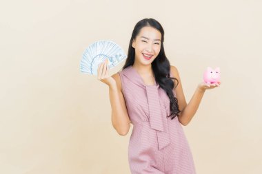 Renkli arka planda domuz kumbarası olan güzel Asyalı kadın portresi