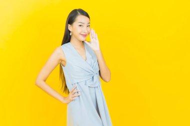 Portre güzel Asyalı kadın gülümsüyor. Renkli arka planda hareket var.