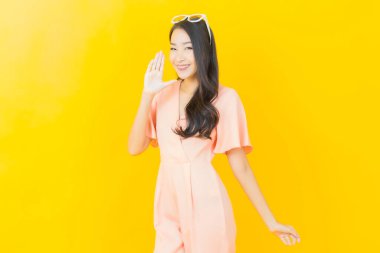 Portre güzel Asyalı kadın gülümsüyor. Renkli arka planda hareket var.