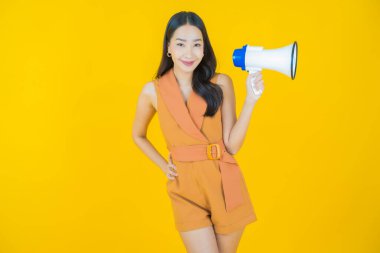Güzel bir Asyalı kadının portresi. Arka planda megafonla gülümsüyor.