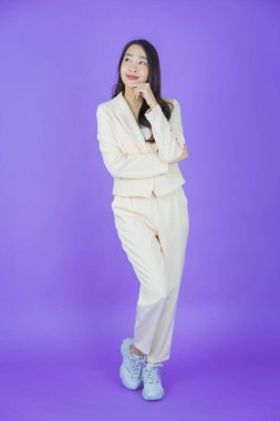 Portre güzel Asyalı kadın gülümsüyor. Renkli arka planda hareket var.