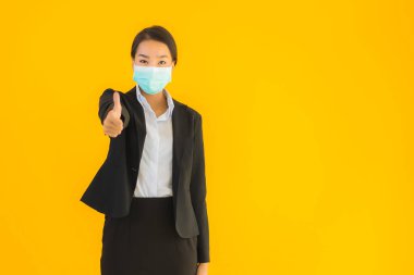 Güzel genç iş kadını portresi Korunmak için maske takıyor 19 koronavirüs sarı izole arka planda