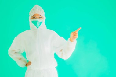 Güzel, genç Asyalı doktor kadın portre. Koronavirüsten ya da mavi arka planda kovid19 'dan korunmak için ppe ya da kişisel koruyucu ekipman takıyor.