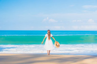 Güzel bir Asyalı kadın portresi. Rahatla. Deniz kıyısı okyanusunda rahatça gülümse.