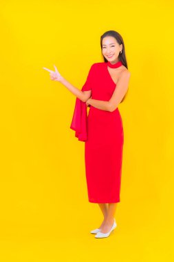 Güzel bir Asyalı kadın portresi. Sarı izole edilmiş arka planda hareketli gülümsüyor.