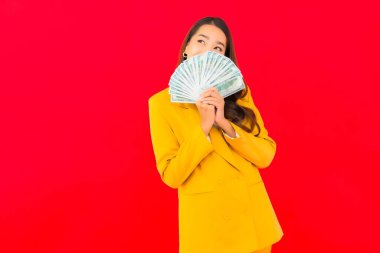 Kızıl arka planda bir sürü parası ve parası olan güzel bir Asyalı kadın portresi.