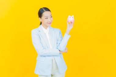 Renkli arka planda domuz kumbarası olan güzel Asyalı kadın portresi