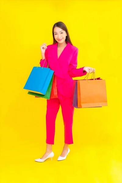 肖像画美しい若いアジアの女性とともにカラフルなショッピングバッグ上の色隔離された背景 — ストック写真