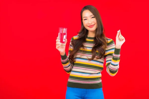 Portret Mooie Jonge Aziatische Vrouw Met Drinkwater Pil Rode Achtergrond — Stockfoto