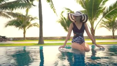 Otelde yüzme havuzunda dinlenen Asyalı güzel bir kadının görüntüsü.