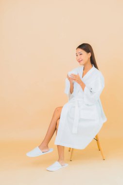 Renkli arka planda kahve fincanı olan güzel bir Asyalı kadın portresi.