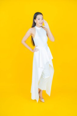 Portre güzel Asyalı kadın gülümsüyor. Renkli arka planda hareket var.