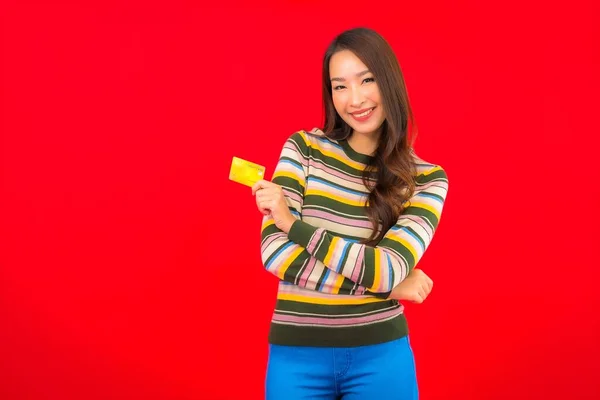 Portret Pięknej Młodej Azjatyckiej Kobiety Kartą Kredytową Czerwonym Izolowanym Tle — Zdjęcie stockowe