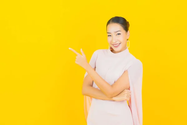 Güzel Asyalı Kadın Gülümsüyor Sarı Arka Planda Birçok Hareket Var — Stok fotoğraf