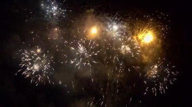 Gece gökyüzünde patlayan havai fişeklerin yakın çekim görüntüleri.