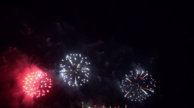 Gece gökyüzünde patlayan havai fişeklerin yakın çekim görüntüleri.
