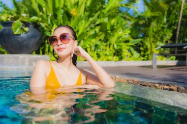 Güzel bir Asyalı kadın portresi. Rahatlayın. Keyifli bir tatil için oteldeki yüzme havuzunda mutlu bir gülümseme.
