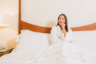 Güzel bir Asyalı kadının portresi. Gülümse. Yatak odasında rahatla.