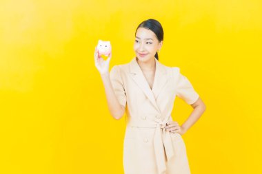 Renkli arka planda domuz kumbarası olan güzel Asyalı kadın portresi