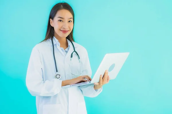 形象漂亮的年轻亚洲医生妇女 有手提电脑 可在诊所或医院使用 背景是蓝色孤立的 — 图库照片