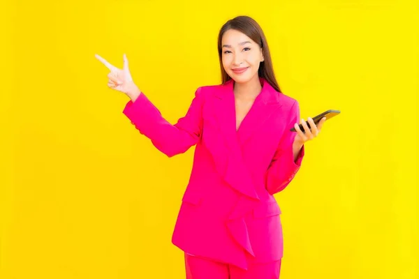 肖像画美しい若いアジアの女性は黄色の色のスマートフォンを使用して隔離された背景 — ストック写真