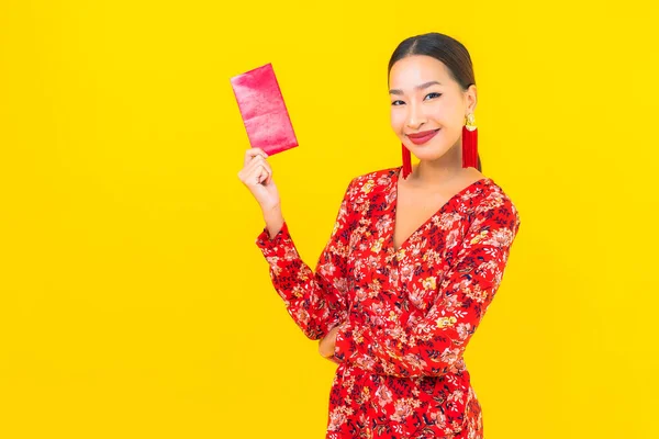 Sarı Arka Planda Kırmızı Zarfları Olan Güzel Asyalı Kadın Portresi — Stok fotoğraf
