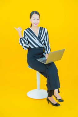 Portre güzel Asyalı kadın gülümsüyor. Renkli arka planda hareket var.