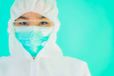 Güzel, genç Asyalı doktor kadın portre. Koronavirüsten ya da mavi arka planda kovid19 'dan korunmak için ppe ya da kişisel koruyucu ekipman takıyor.