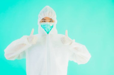 Güzel, genç Asyalı doktor kadın portre. Koronavirüsten ya da mavi arka planda kovid19 'dan korunmak için ppe ya da kişisel koruyucu ekipman takıyor.