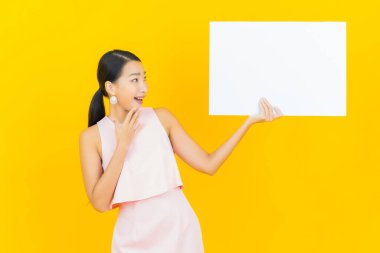 Sarı arka planda boş beyaz ilan panosu olan güzel Asyalı kadın portresi