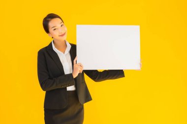 Güzel bir portre. Genç Asyalı kadın, sarı izole edilmiş arka planda boş beyaz tahta gösteriyor.