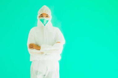 Güzel, genç Asyalı doktor kadın portre. Koronavirüsten ya da mavi arka planda kovid19 'dan korunmak için ppe ya da kişisel koruyucu ekipman takıyor.