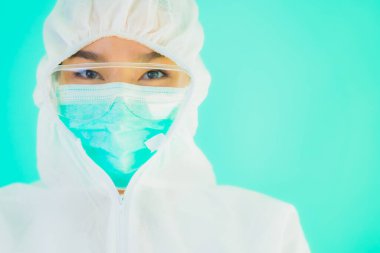 Güzel, genç Asyalı doktor kadın portre. Koronavirüsten ya da mavi arka planda kovid19 'dan korunmak için ppe ya da kişisel koruyucu ekipman takıyor.
