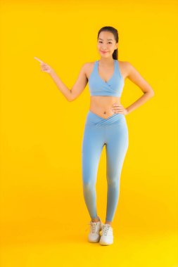 Sarı izole edilmiş arka planda spor giysili güzel Asyalı kadın portresi egzersize hazır.