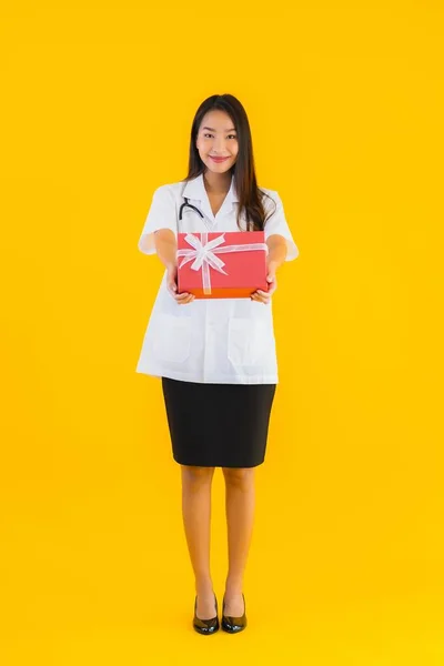 Porträt Schöne Junge Asiatische Ärztin Zeigt Rote Geschenkschachtel Auf Gelbem — Stockfoto