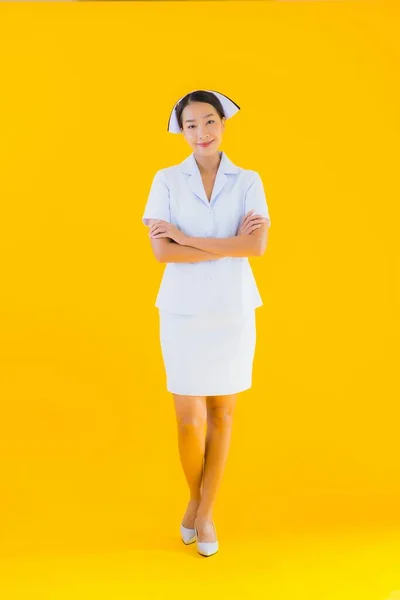 노란색외진 배경에 클리닉 병원에서 환자를 활동을 아름다운 이시아 계젊은 간호사의 — 스톡 사진
