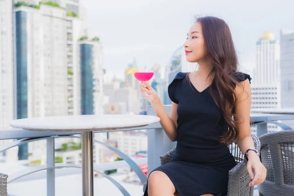Portrait beautiful young asian woman enjoy with cocktails drink glass on rooftop bar and restaurant