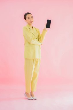 Güzel Asyalı iş kadını portresi. Arka planda kahve fincanı ve akıllı cep telefonu kullanıyor.