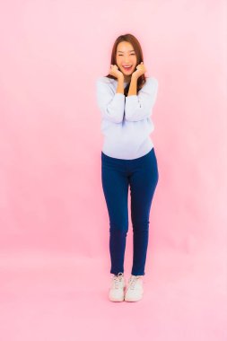 Portrait beautiful young asian woman smile with action on pink isolated background