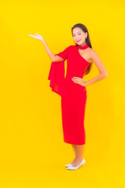 Güzel bir Asyalı kadın portresi. Sarı izole edilmiş arka planda hareketli gülümsüyor.