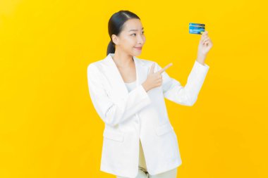 Güzel bir Asyalı kadının portresi. Renkli kredi kartıyla gülüyor.